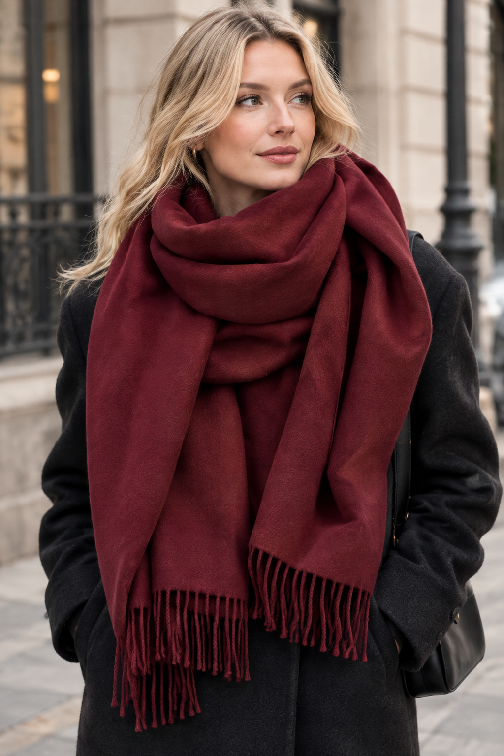 Femme blonde portant une grosse écharpe bordeaux en laine et cachemire